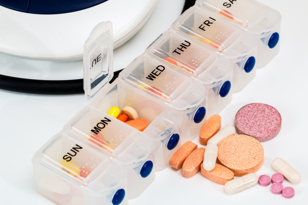 Weißer Tisch mit Pillendose, Stethoskop und Etikett