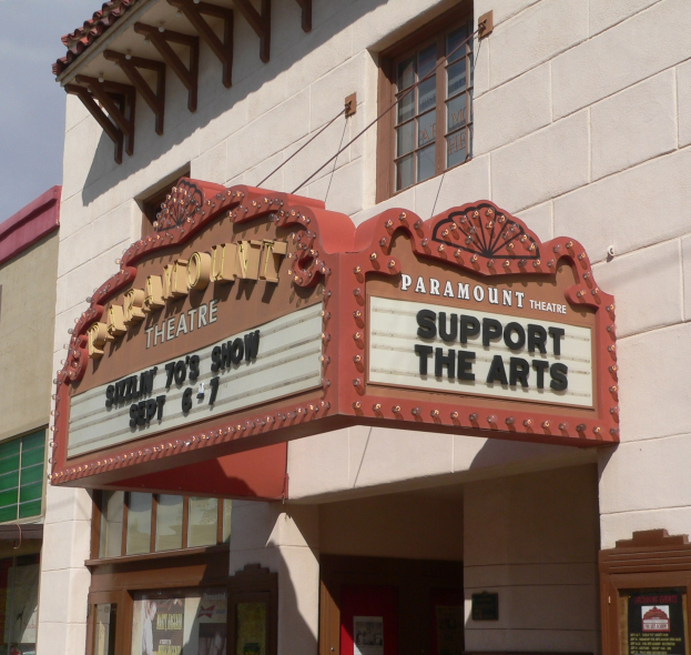 Außenansicht des Paramount Theatre in Sacramento, Kalifornien, mit Glasfenstern und -türen und einer 'Support the Arts'-Schrifttafel über dem Eingang sowie einem sichtbaren Himmel im Hintergrund.