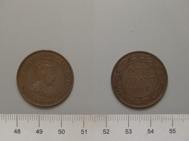 Zwei Ein-Cent-Münzen nebeneinander auf einem Lineal auf einer weißen Oberfläche.