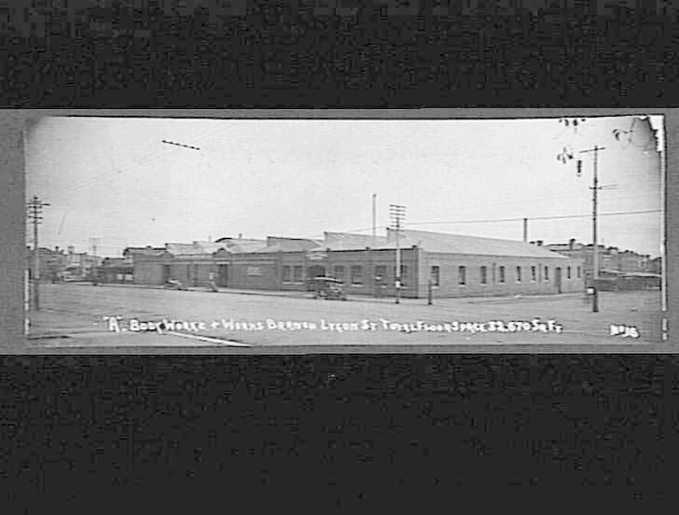 Schwarzes und weißes Foto einer Stadtstraße mit Gebäuden, Strommasten, Kabeln, Fahrzeugen und einem Himmel, beschriftet mit "Book House and Works, Bergen, Oregon" unten.