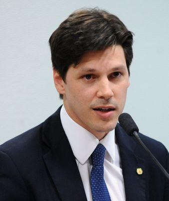 Ein Mann im Anzug und Krawatte spricht in ein Mikrofon an einem Rednerpult, wahrscheinlich zur Genehmigung eines Gesetzes durch die Regierung, das den Internetgebrauch verbietet.