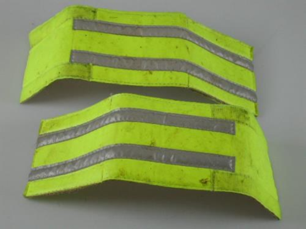 Zwei gelbe reflektierende Sicherheitswesten auf einer weißen Fläche, für hohe Sichtbarkeit entworfen.