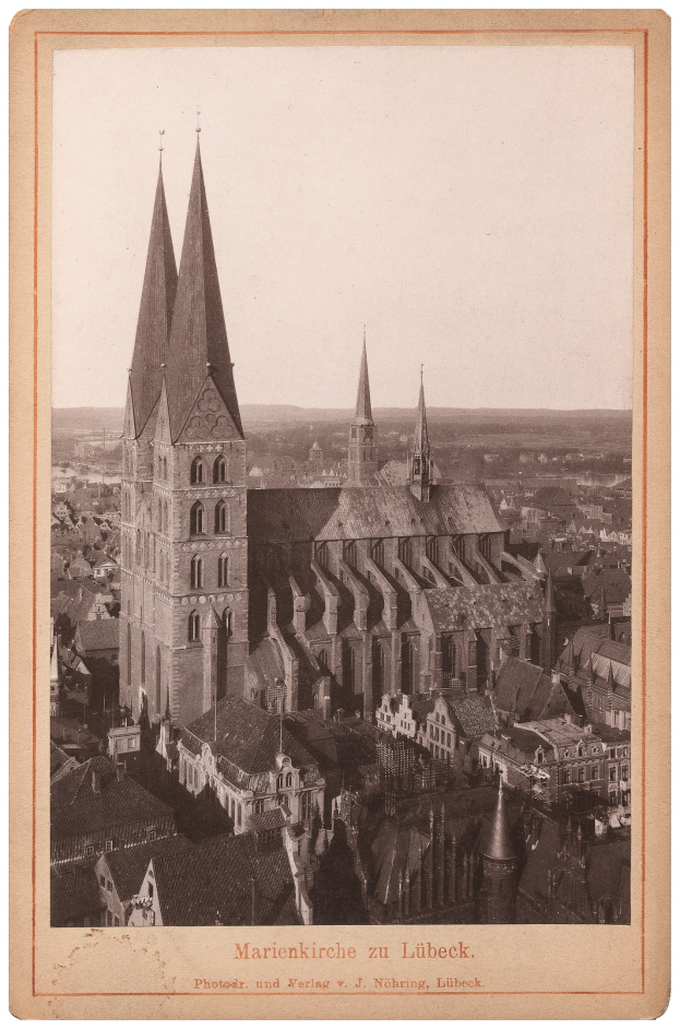 Schwarz-weiß-Fotografie einer Stadt mit einer zentralen Kirche, umgeben von Gebäuden, mit Text unten.