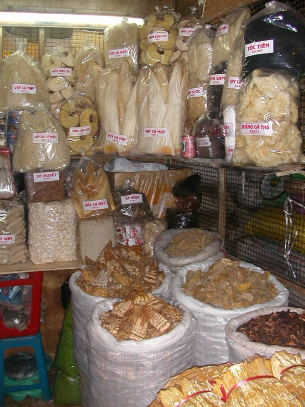Ein gut organisierter Marktstand mit ordentlich sortierten Lebensmitteln in Tüten und Plastikabdeckungen.