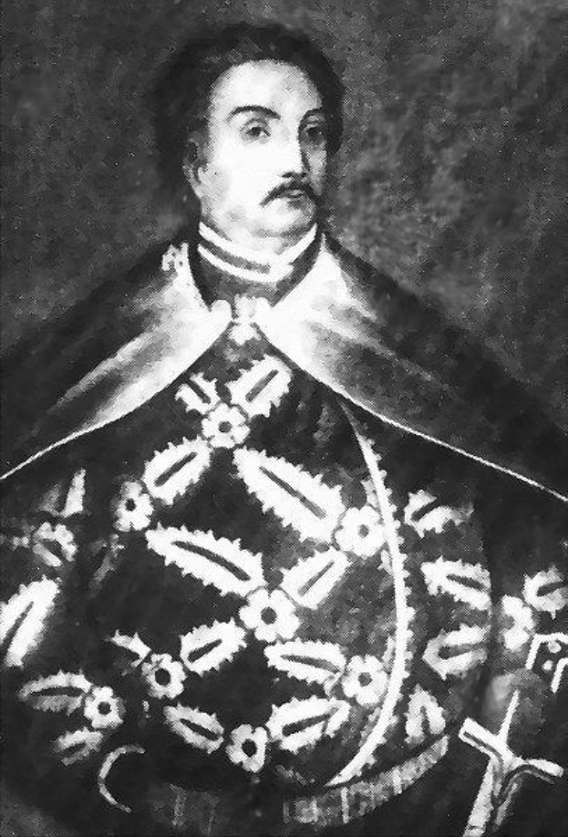 Schwarzes und weißes Foto von Papst Johannes Paul II. in Priesterrobe, der eine schwarze Robe mit weißem Kragen und Manschetten trägt und die Hände falt, mit ernstem Gesichtsausdruck und direktem Blick.