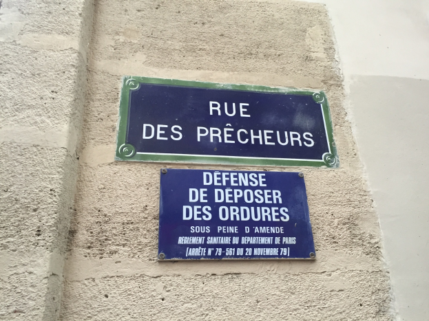 Zwei blaue und weiße Straßenschilder an der Seite eines Gebäudes angebracht