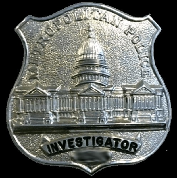 Ein silbernes Polizeibadgebnis mit der Aufschrift "Investigator" vor einem weißen Hintergrund.